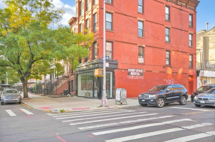 The building seen from across the intersection, showing the tree-lined corner