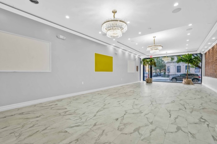 Wide view of the hall showing the marble floor and chandeliers