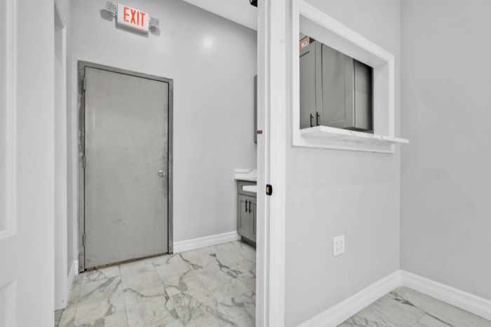 Rear service corridor with the private load-in door and pantry pass-through